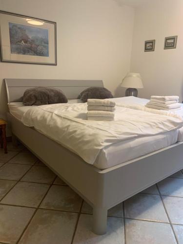 a large bed with white sheets and pillows on it at Sylter Rose 3A in Süderende