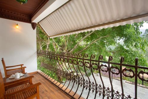 a balcony with a view of the trees at Koviloor Resort in Vattavada