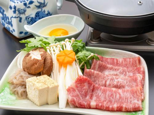 a plate of food with meat and vegetables on a stove at Yunotani Senkei in Totsukawa