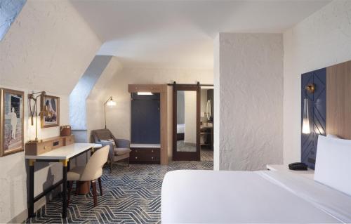 a hotel room with a bed and a desk at Hotel Royer Urbana Champaign, Tapestry Collection by Hilton in Champaign
