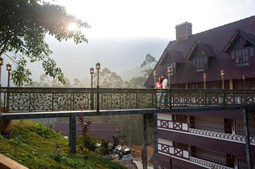 two people standing on a bridge in a village at Koviloor Resort in Vattavada