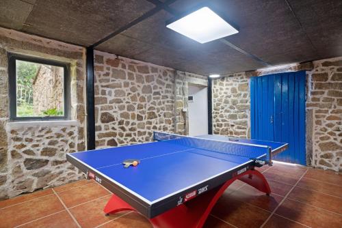 a ping pong table in a room with a stone wall at 平潭游记猫头墘古村落 in Pingtan