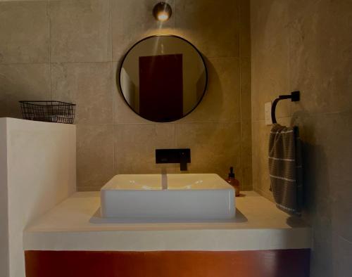 Un baño con un lavabo blanco y un espejo. en Casa Palma, en Campeche