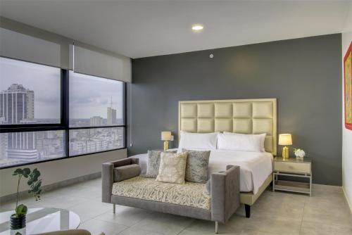 a bedroom with a bed and a chair and windows at DoubleTree by Hilton Guayaquil in Guayaquil
