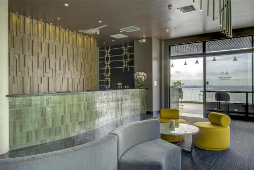 a lobby with a couch and a table and chairs at DoubleTree by Hilton Guayaquil in Guayaquil