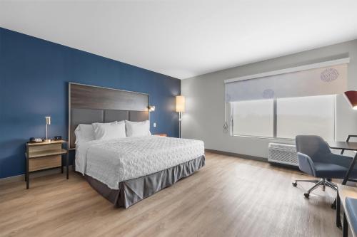a hotel room with a bed and a desk and chair at Tru By Hilton Cape Girardeau in Cape Girardeau