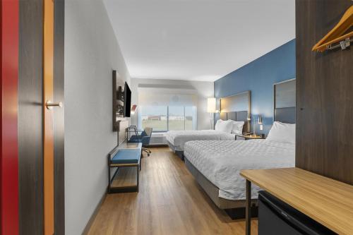 a hotel room with two beds and a desk at Tru By Hilton Cape Girardeau in Cape Girardeau