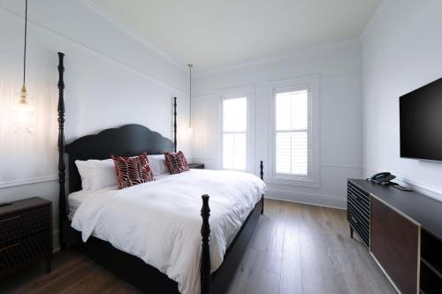 a bedroom with a large bed and a flat screen tv at Fairmount Hotel, in the Unbound Collection by Hyatt in San Antonio