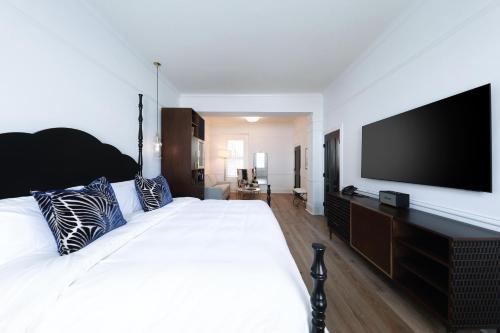 a bedroom with a large bed with a flat screen tv at Fairmount Hotel, in the Unbound Collection by Hyatt in San Antonio