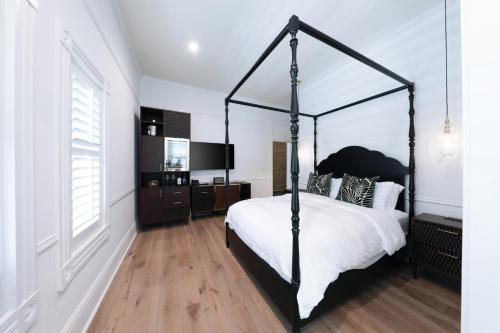 a bedroom with a black canopy bed with white sheets at Fairmount Hotel, in the Unbound Collection by Hyatt in San Antonio