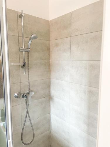 une douche avec pommeau de douche dans une salle de bain dans l'établissement T2 Saint Cyprien proche de la mer, à Lecci