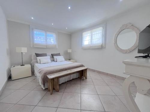 une chambre blanche avec un lit et un miroir dans l'établissement Charming villa with pool, à Montpellier