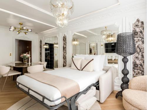 une chambre blanche avec un grand lit et une table dans l'établissement Merveil - Luxury Suite - Louvre - Aboukir IX, à Paris