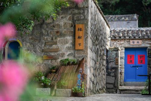 a stone building with a blue and red door at 平潭游记猫头墘古村落 in Pingtan