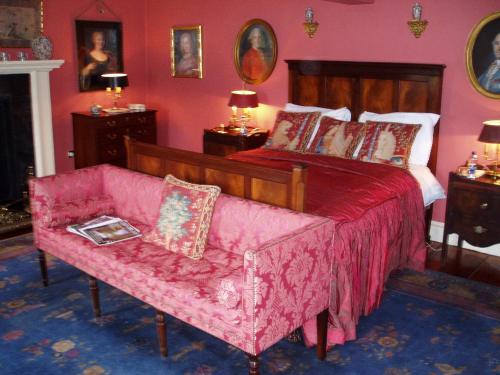 a bedroom with a bed and a pink couch at Collon House in Collon