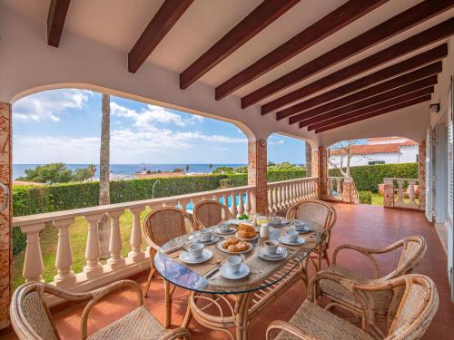 Una mesa en un balcón con vista al mar. en Villa Sur, en Binisafua