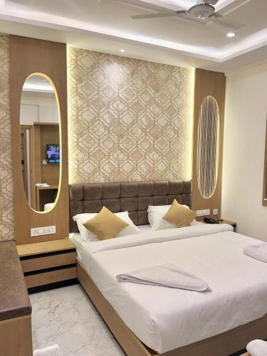 a bedroom with a large bed and a mirror at UPTOWN Inn in Bengaluru