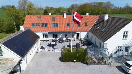 an aerial view of a large white house with a flag at Marielyst Sleep´n Go in Væggerløse
