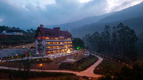 a large building with lights in front of a mountain at Koviloor Resort in Vattavada