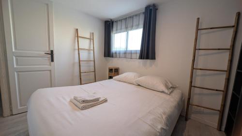 - une chambre avec un lit blanc et une serviette dans l'établissement Appartement T3 , 650m du Palais des Festivals, à Cannes