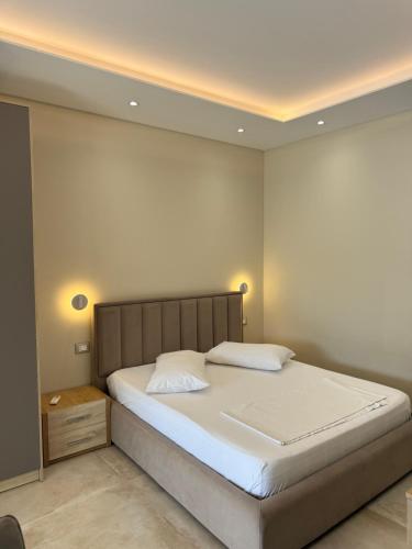 a bedroom with a large bed with white sheets at Arial Trinity Suites in Vlorë