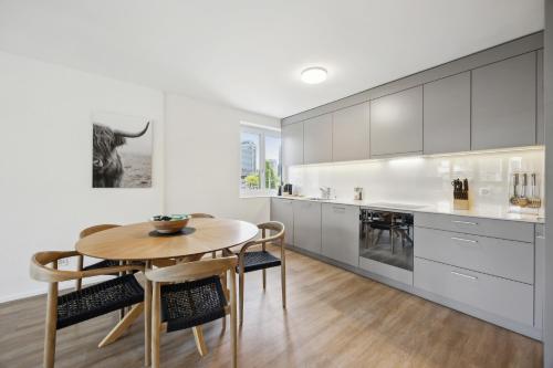 a kitchen with a wooden table and a dining room at UP&GREAT Apartments - Chic Urban Homes in Zürich