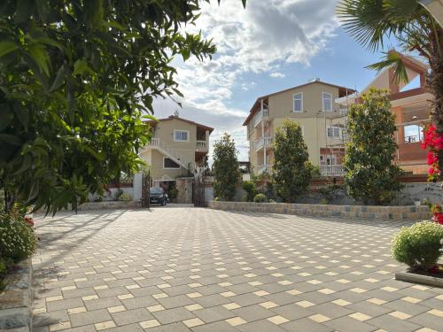 a courtyard in a villa with trees and buildings at Arial Trinity Suites in Vlorë