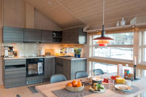 una cucina con un tavolo con una ciotola di arance sopra di Sørbølhytta by Norgesbooking - cabin in Flå, close to Bjørneparken a Flå