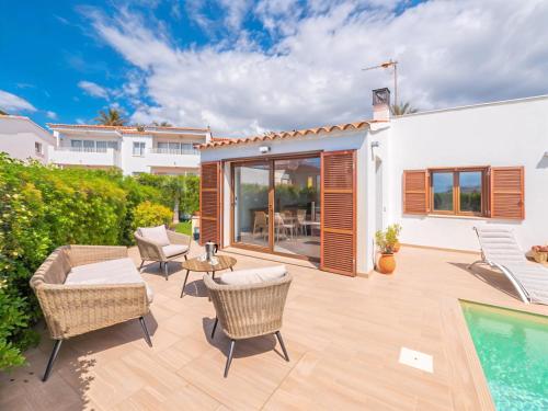 サルガールにあるVilla Serenaの椅子とプールのあるパティオ