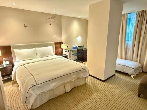 a hotel room with a large bed and a desk at K Hotel Taipei Dunnan in Taipei