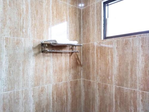 a bathroom with a shower with a towel at Roemah Kavaleri powered by Cocotel in Bandung