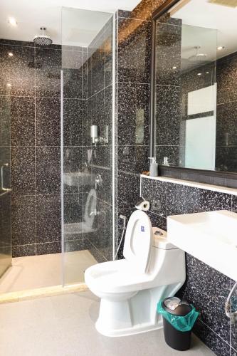 a bathroom with a toilet and a shower and a sink at Bonheur at Karambunai in Kota Kinabalu