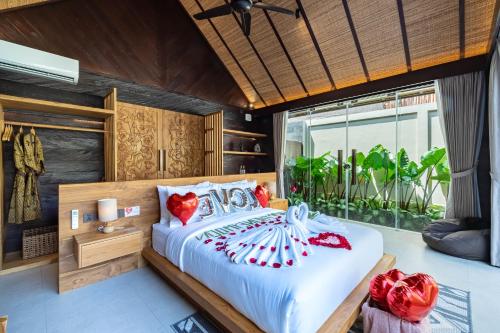 a bedroom with a large white bed with red pillows at Villa Dijabu in Kuta