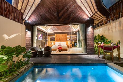 a villa with a swimming pool and a bedroom at Villa Dijabu in Kuta