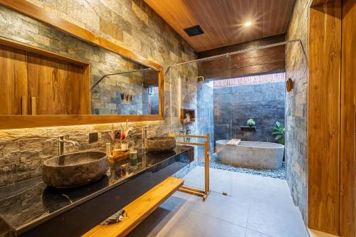 a bathroom with two sinks and a tub at Villa Dijabu in Kuta