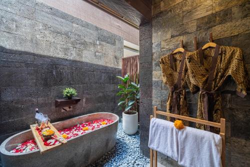 a bathroom with a bath tub filled with flowers at Villa Dijabu in Kuta