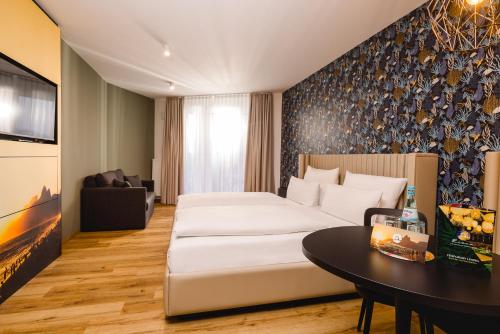 a hotel room with a bed and a table at Rioca Hafeninsel Posto 8 in Offenbach