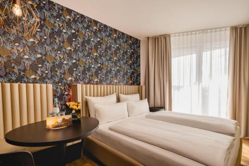 a bedroom with a large bed and a table at Rioca Hafeninsel Posto 8 in Offenbach