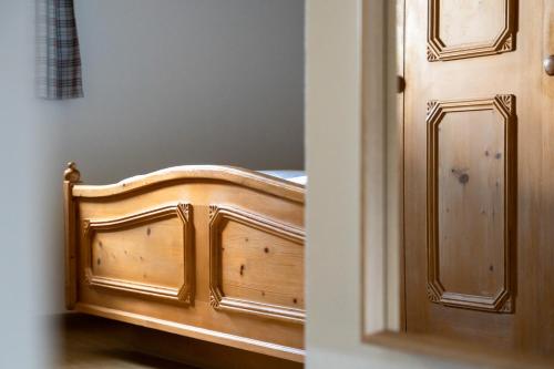 a bedroom with a wooden bed next to a door at Boutiquehotel ZOMM in Seefeld in Seefeld in Tirol