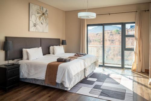 Un dormitorio con una cama grande y una ventana grande en 910 Highland Gate Golf & Trout Estate, en Dullstroom