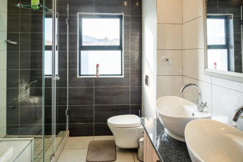 Un baño con inodoro, lavabo y ducha. en 910 Highland Gate Golf & Trout Estate, en Dullstroom