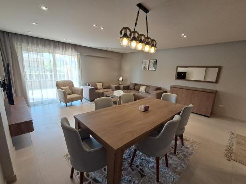 a dining room and living room with a table and chairs at شقة فندقية فى الشيخ زايد داخل كمبوند حديقة خاصة ومدخل خاص in Sheikh Zayed