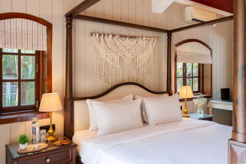 a bedroom with a canopy bed with white pillows at Beachside Bliss Villas Candolim 10 min walk from Sinquerim Beach in Sinquerim