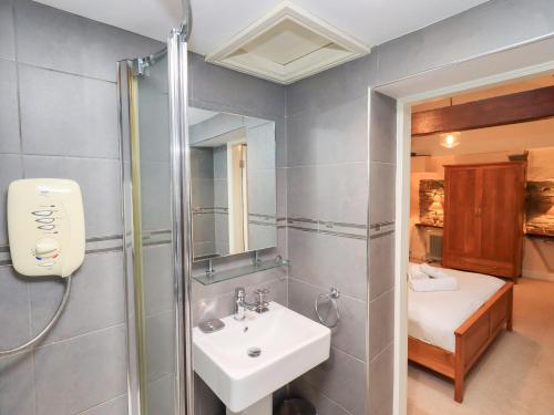 un baño con lavabo y ducha en Old Coach House, en Ambleside
