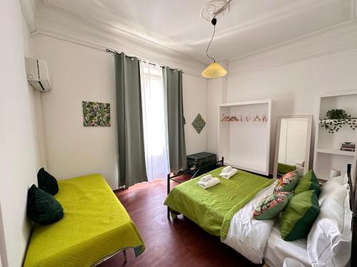 a bedroom with a green bed and a yellow blanket at Via Zara Arararooms in Palermo