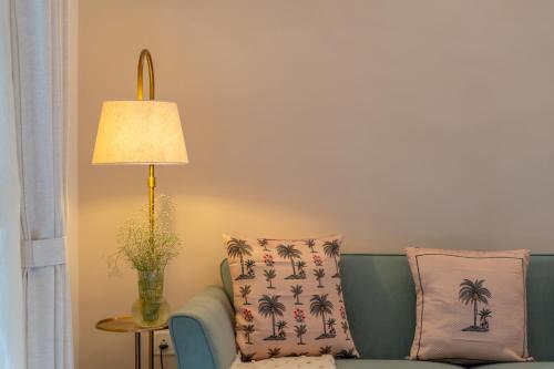 a living room with a green couch and a lamp at Beachside Bliss Villas Candolim 10 min walk from Sinquerim Beach in Sinquerim