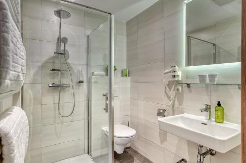 a bathroom with a shower and a toilet and a sink at Boutiquehotel ZOMM in Seefeld in Seefeld in Tirol