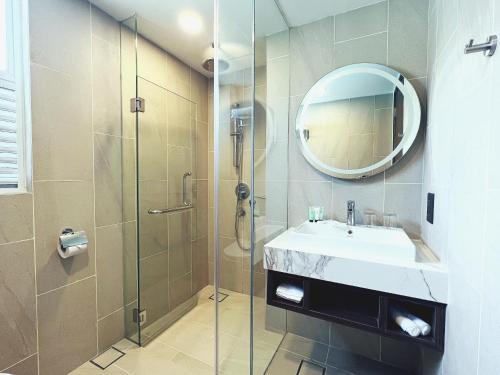 bagno con doccia, lavandino e specchio di Villea Port Dickson a Port Dickson