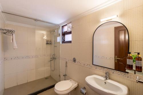 a bathroom with a sink and a toilet and a mirror at Beachside Bliss Villas Candolim 10 min walk from Sinquerim Beach in Sinquerim