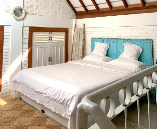 łóżko z niebieskim zagłówkiem w sypialni w obiekcie Rumah Kayu Yogyakarta By Hamsa Putih w mieście Yogyakarta